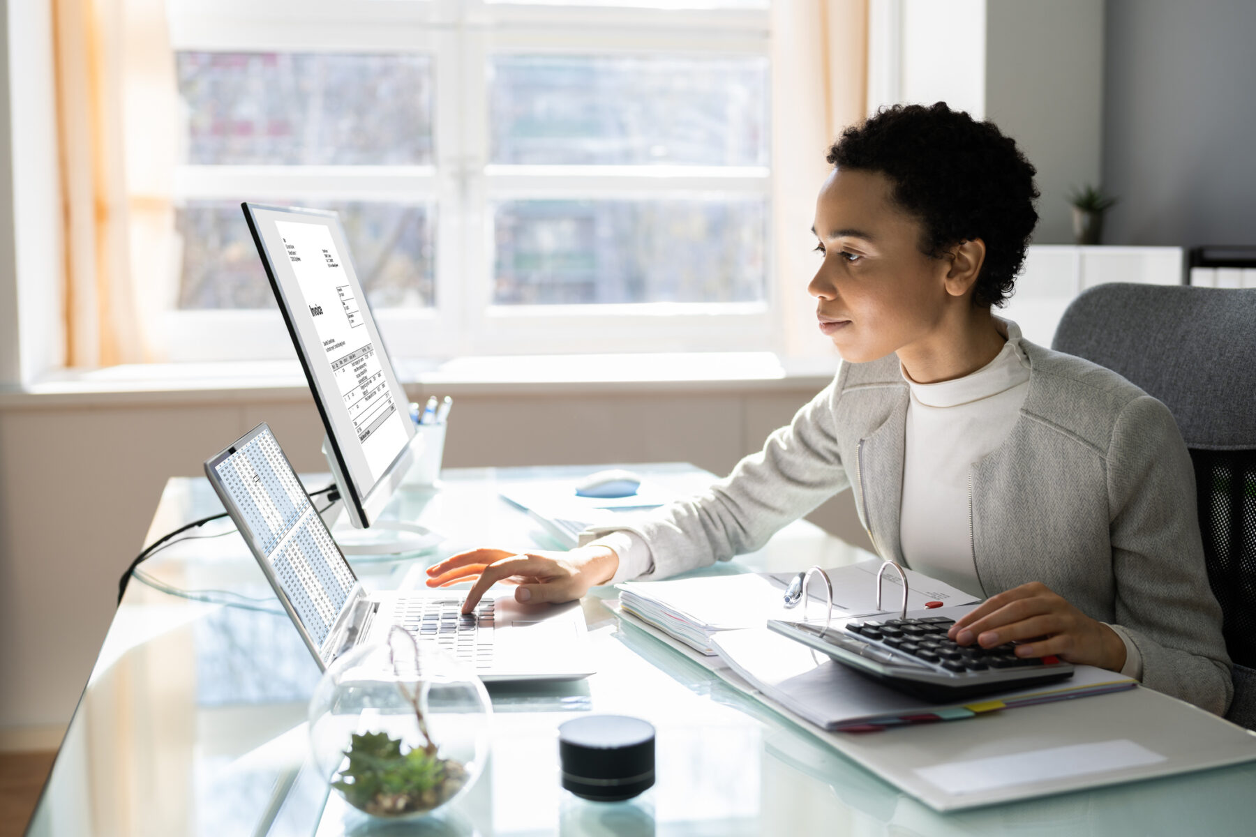 A woman working on a computer, potentially decarbonizing her sme